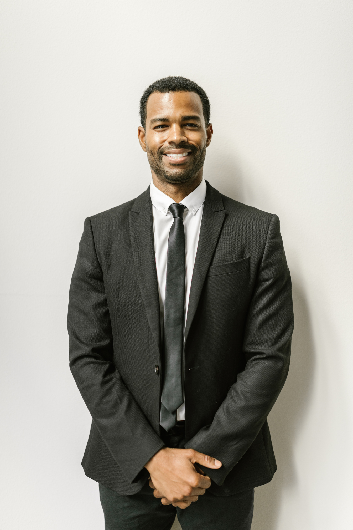 Man in Black Suit Smiling at the Camera